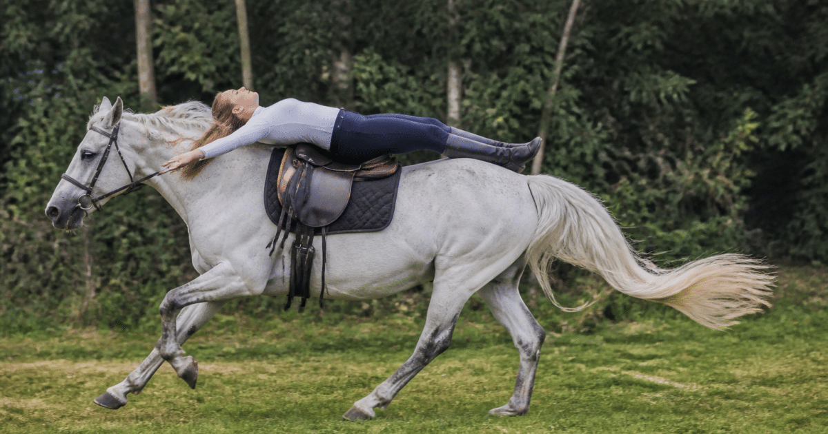 Cavalier allonge sur le dos du cheval au galop