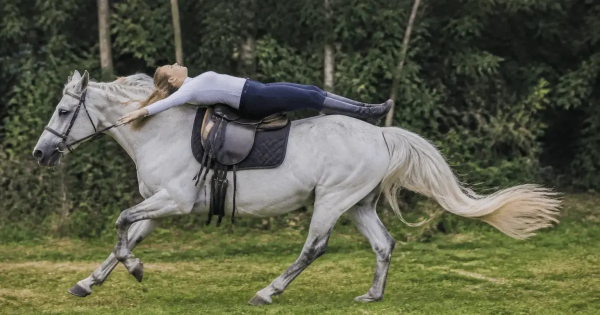 Cavalier allonge sur le dos du cheval au galop