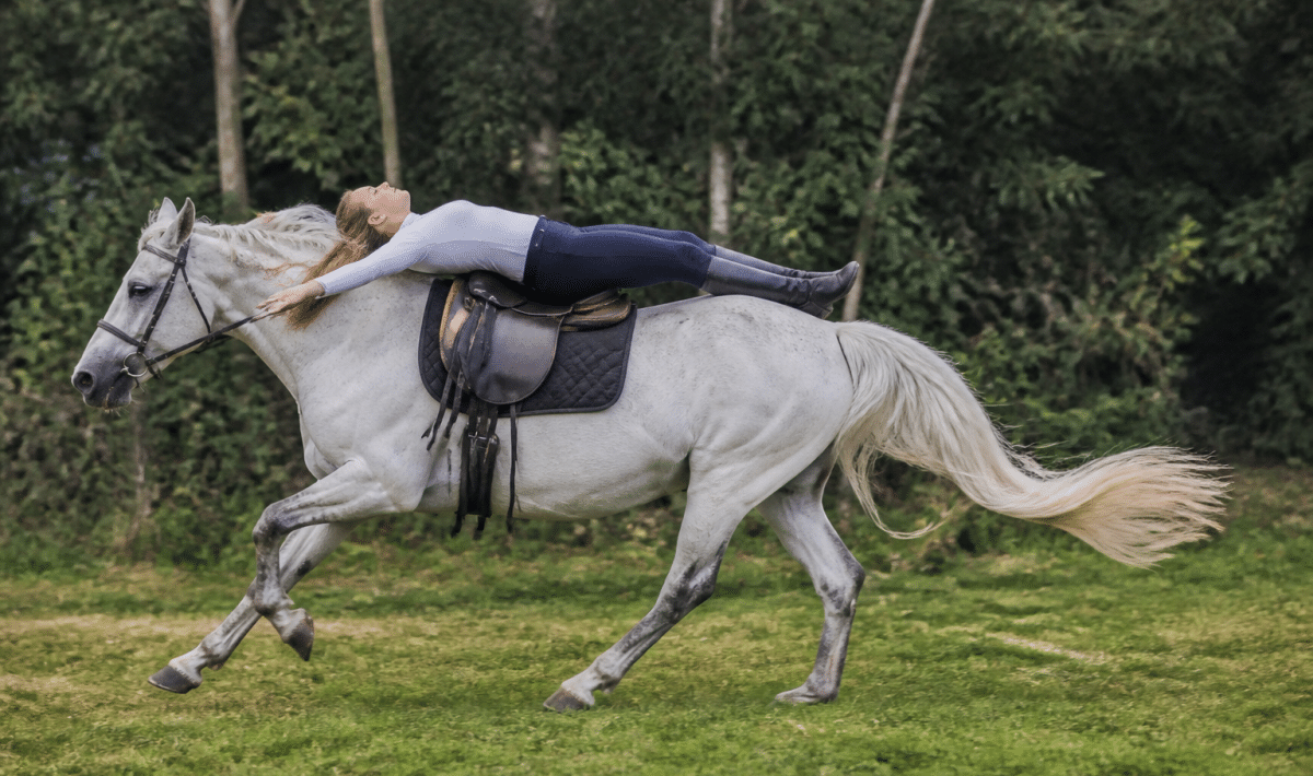 Cavalier allonge sur le dos du cheval au galop