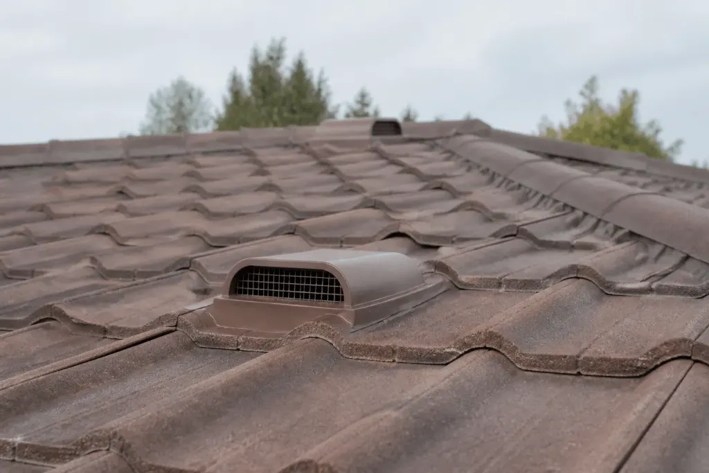 Toiture avec grilles de ventilation et tuiles bien scellees
